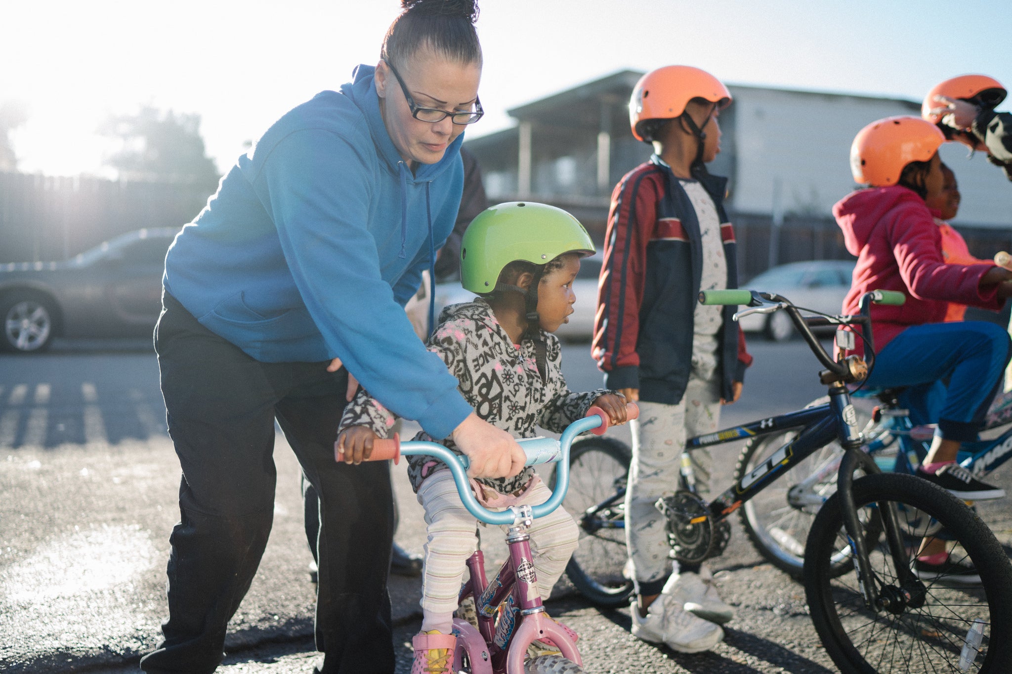Chey helping girl on bike