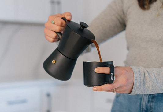 A person using the MiiR New Standard Moka Pot