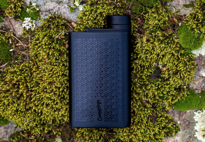 A MiiR x Carryology Aero Flask laying on moss covered rock