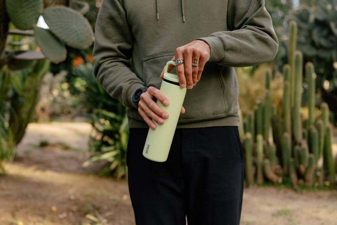 A man holding a MiiR Wide Mouth Bottle in Cactus Green