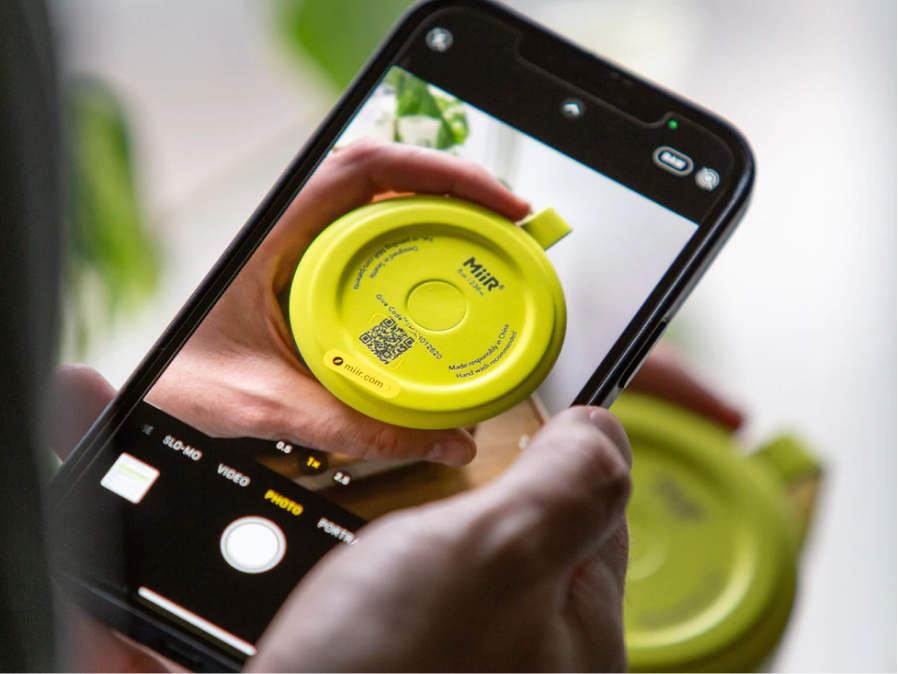 A person scanning the Give Code on the bottom of a MiiR Camp Cup